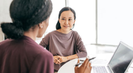 Two women taking over computer