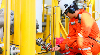 Oil rig employee working on pipes