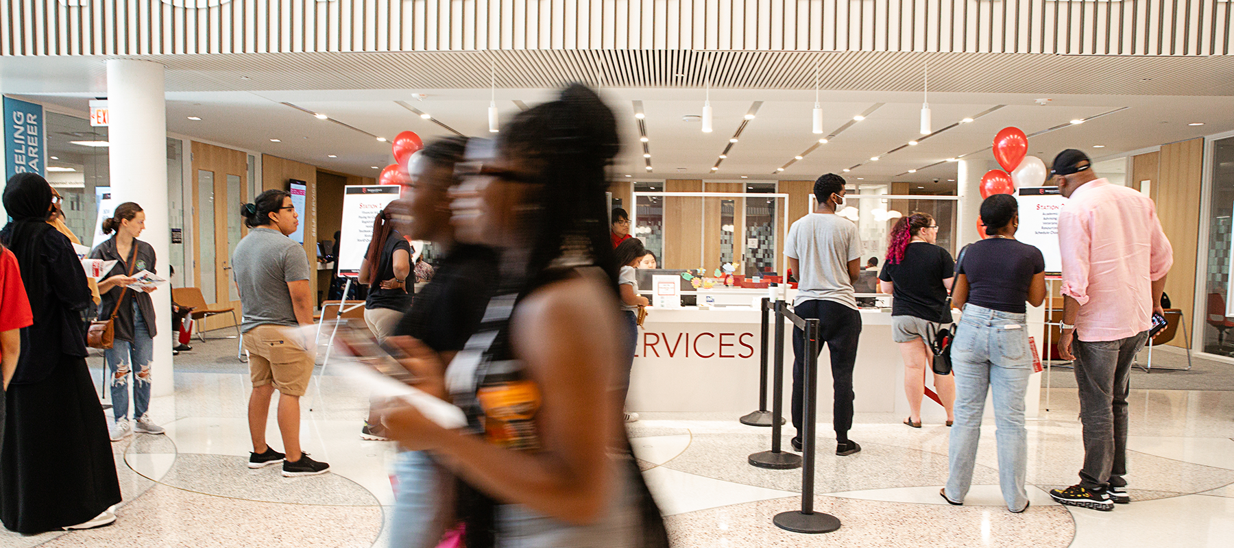 Students, staff, and family members mill about at a new student kickoff event. 