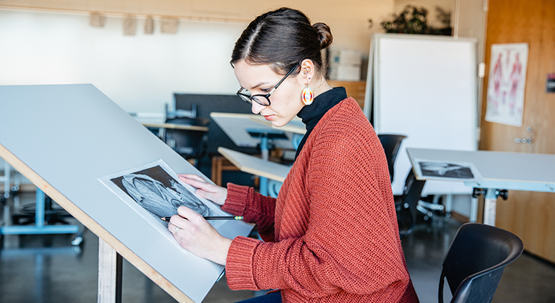 A Normandale returning student takes an art class.