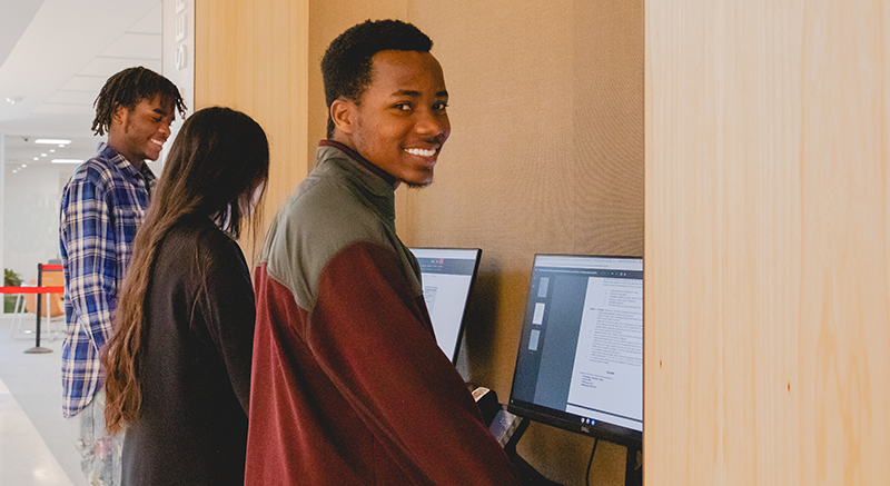 Three students work at computers.