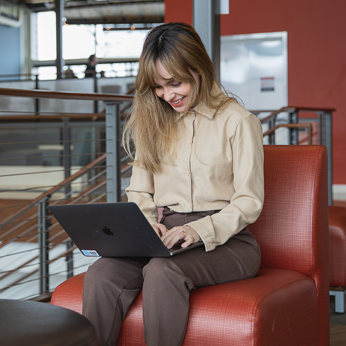 A student works on a laptop on her lap.