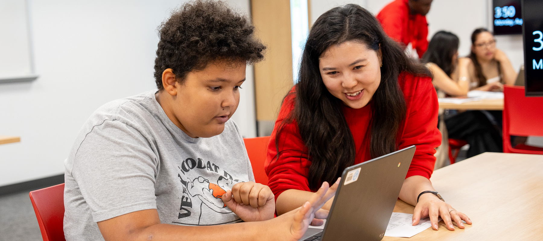 Students work on their laptop together.