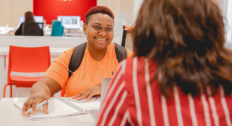 A student smiles at her advisor.