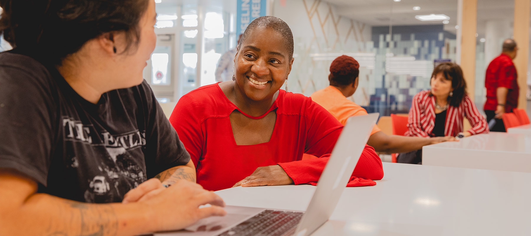 An advisor smiles at a student during a meeting.