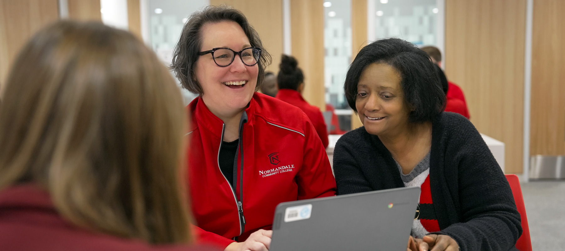 An advisor smiles at a student during a meeting.