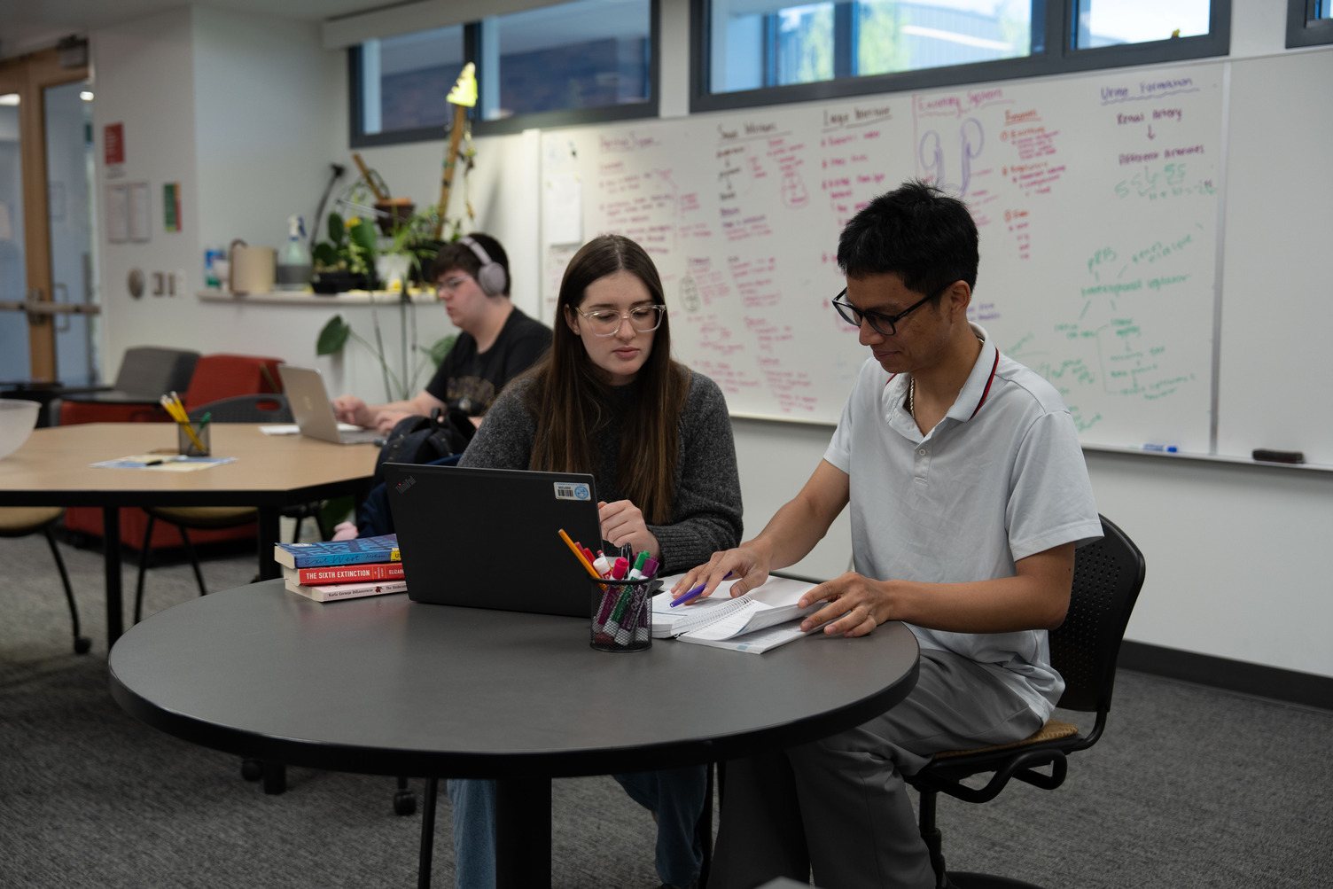 Two students work on a laptop.