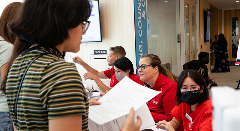 Students work with staff to fill out financial aid paperwork.