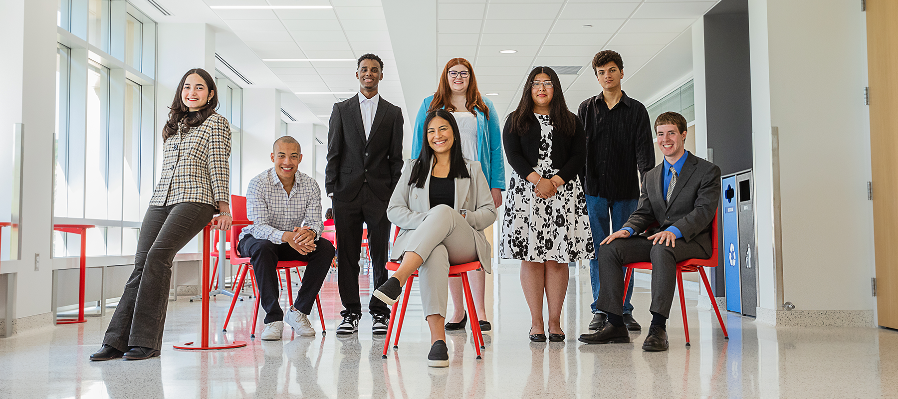 A diverse group of Normandale students in professional dress smiling at the camera.