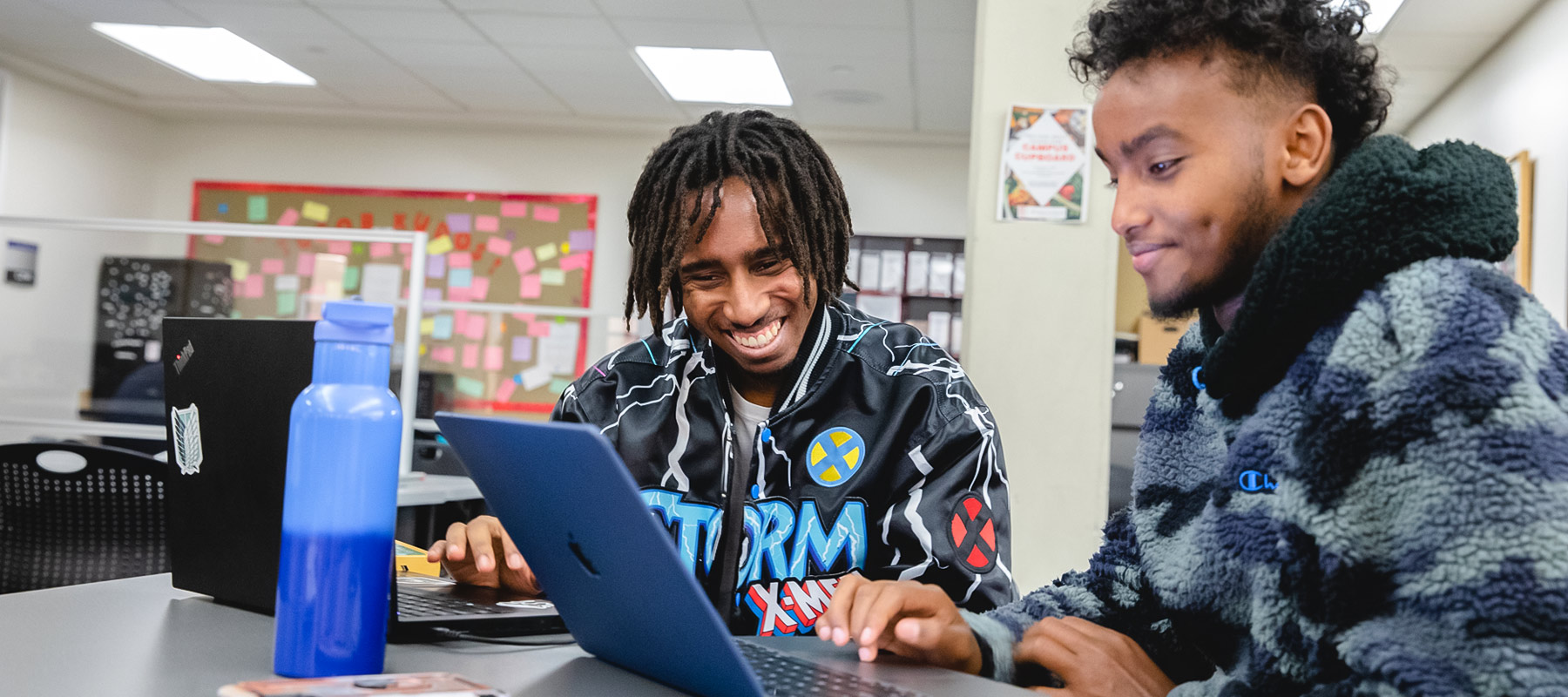 Two Normandale students work on a laptop.