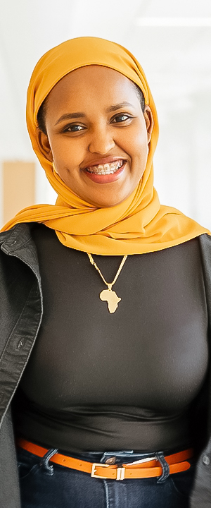 A Normandale student in a yellow headscarf smiles.