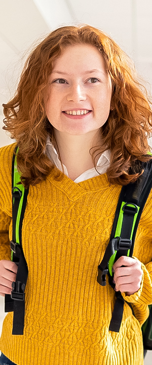 A Normandale student in a yellow sweater smiles.