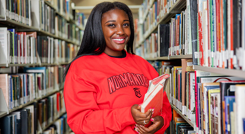 A Normandale student picks books from the library. 