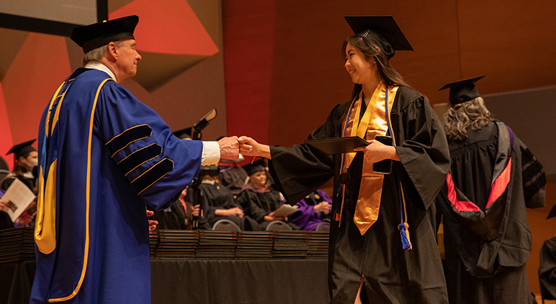 A Normandale student receives their diploma. 