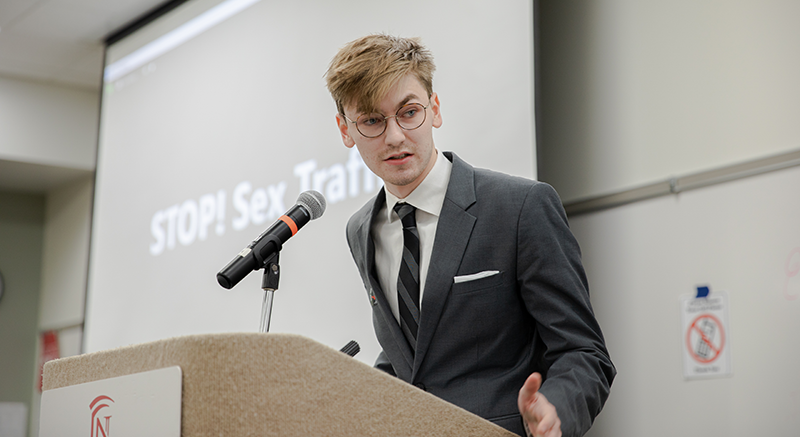 A Normandale student speaks at a podium. 