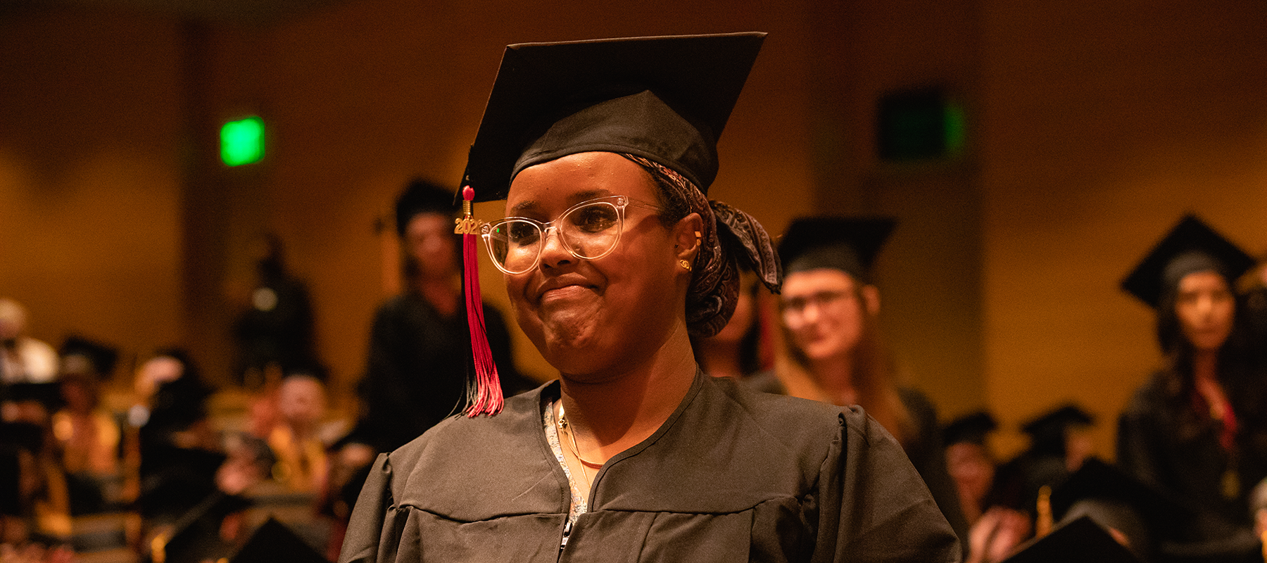 Student smiles in her cap and gown.