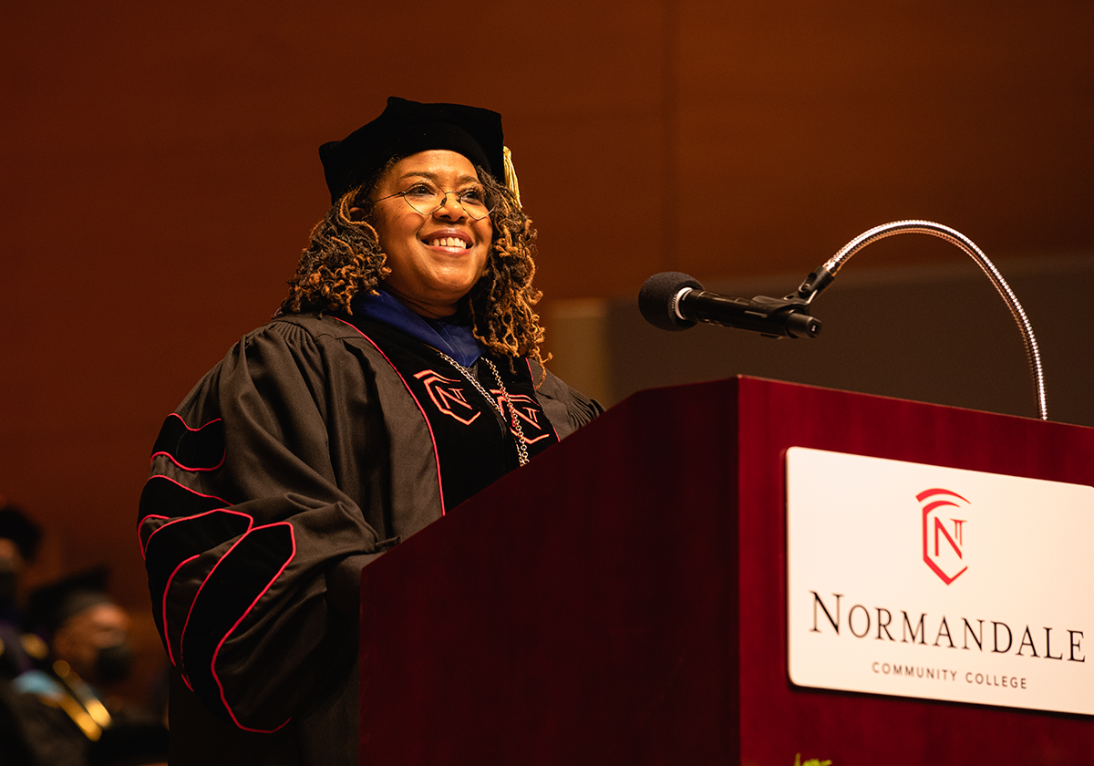 President Ester speaks from a podium at Graduation.