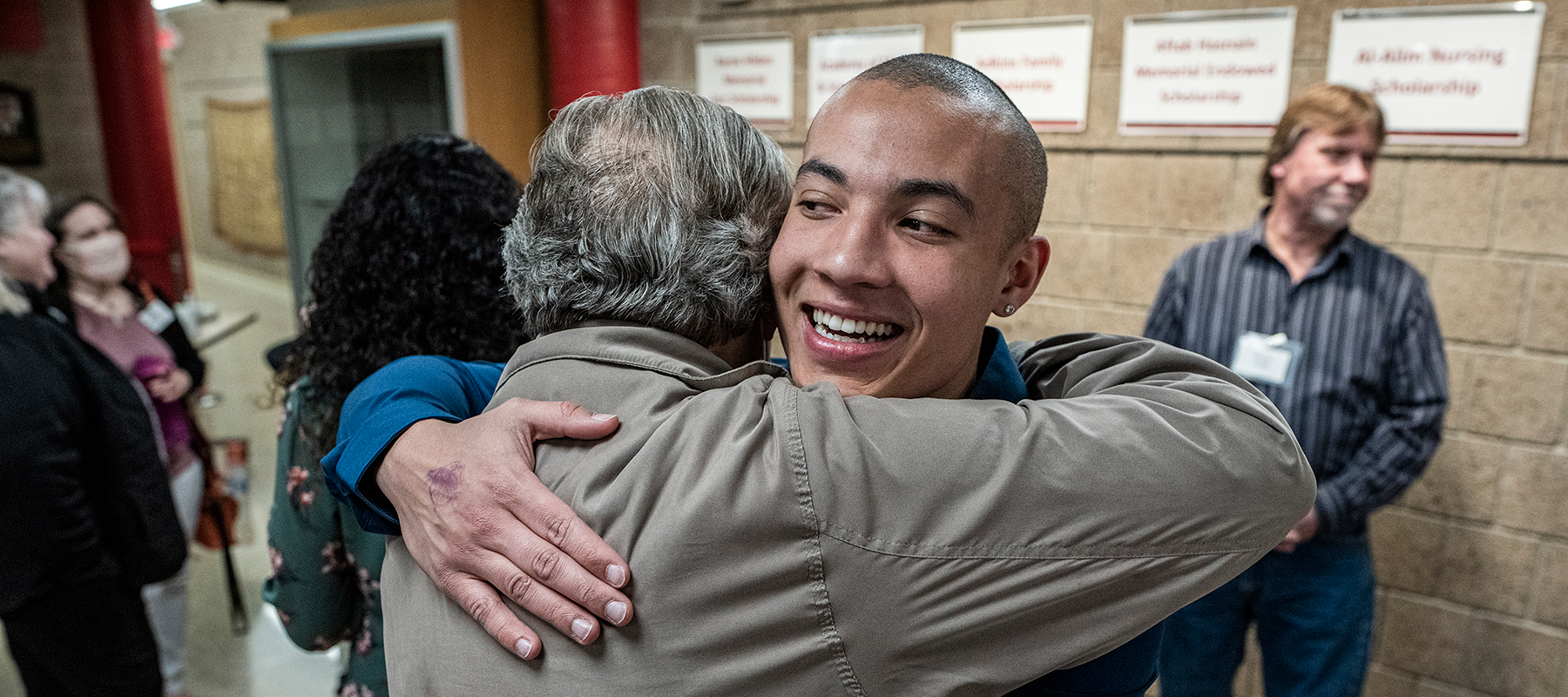 Scholarship recipient Pedro gives a donor a hug