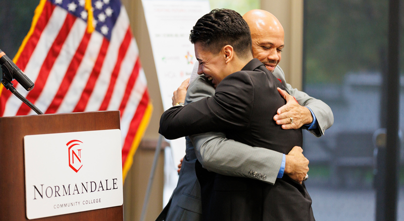 A Normandale staff member hugs a student